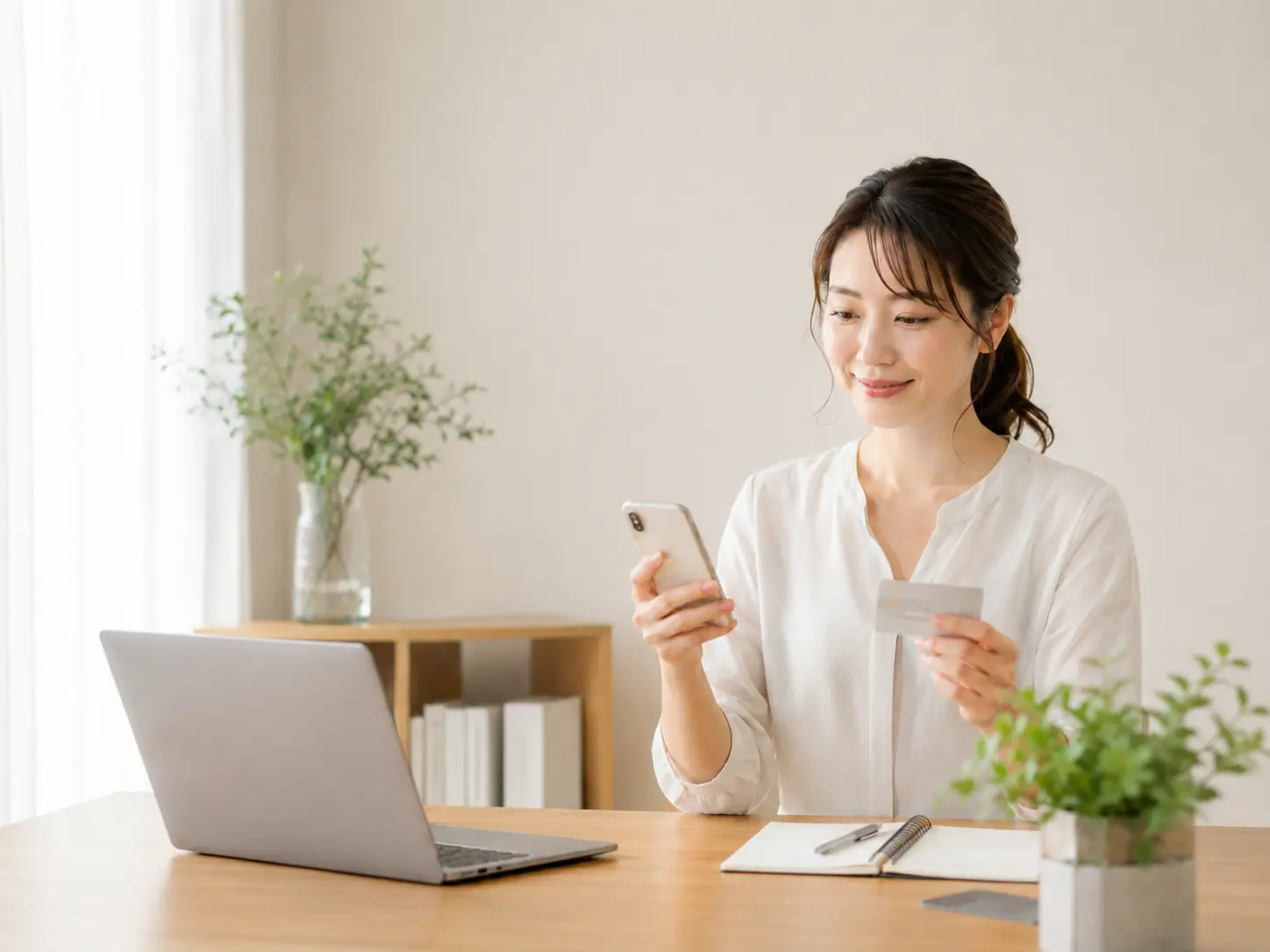 スマートフォンとカードを確認する女性